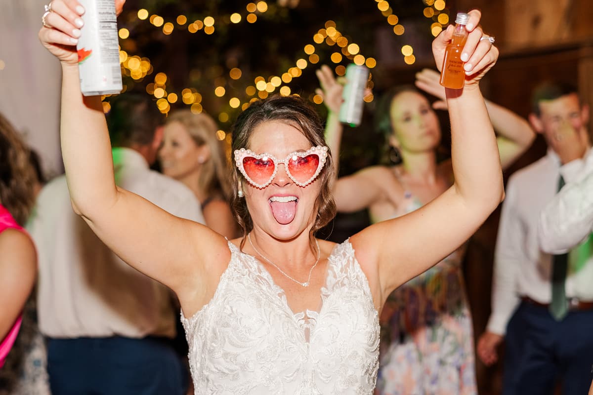Bride partying with heart sunglasses at reception