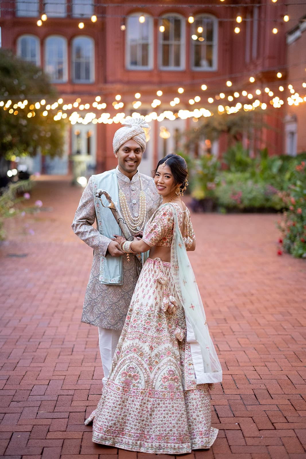 Couple portrait in traditional attire with fairy lights
