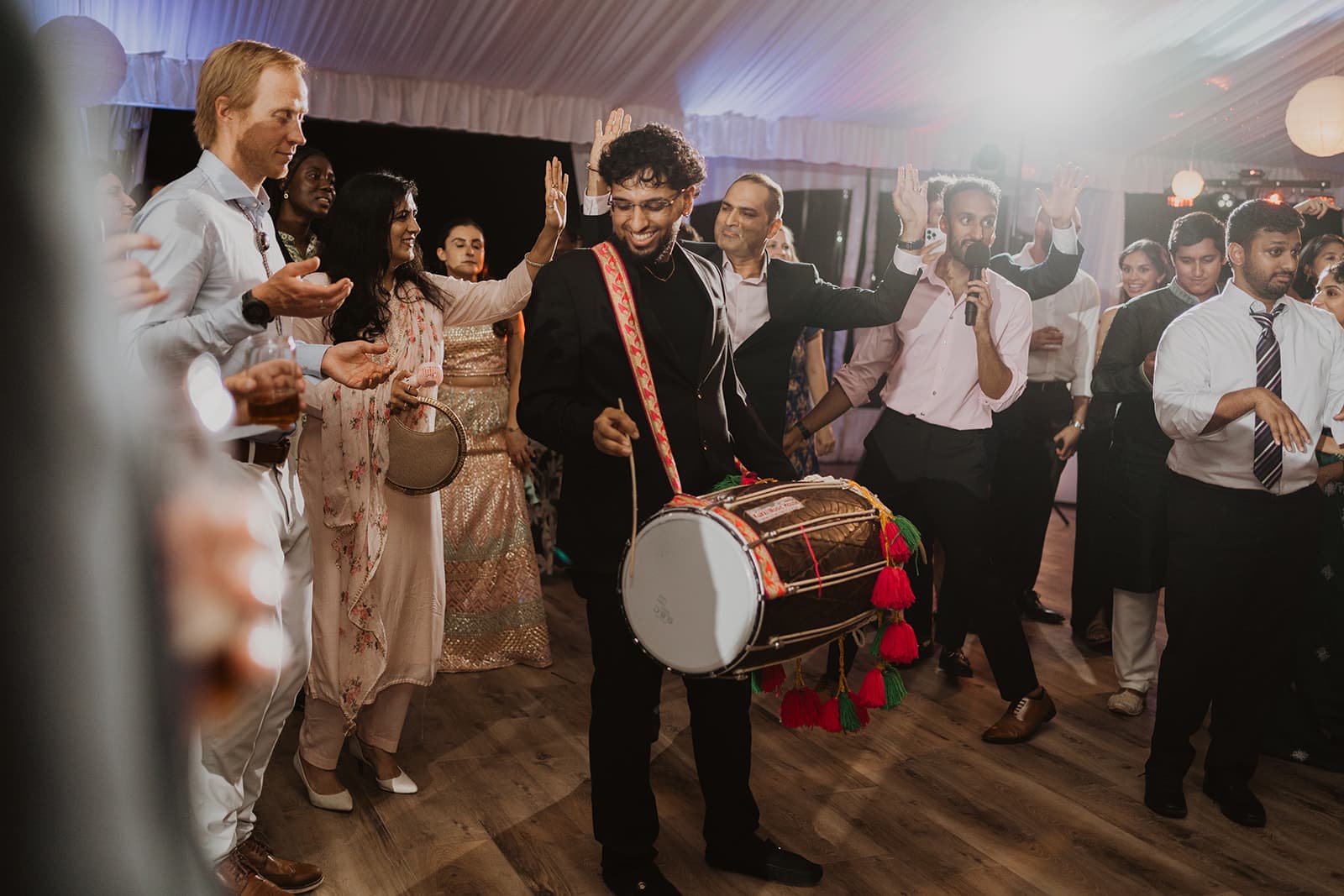 Hartaj playing dhol at wedding reception with high energy crowd
