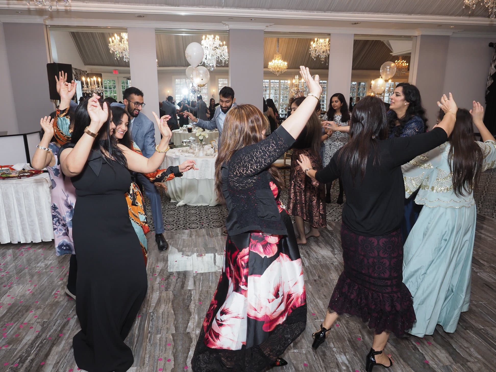 DJ Taj at a packed celebration with colorful lighting