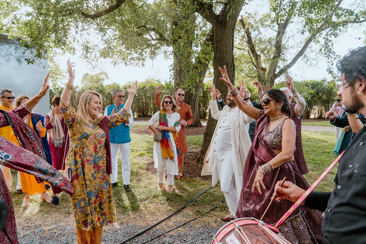 Outdoor baraat celebration with guests dancing