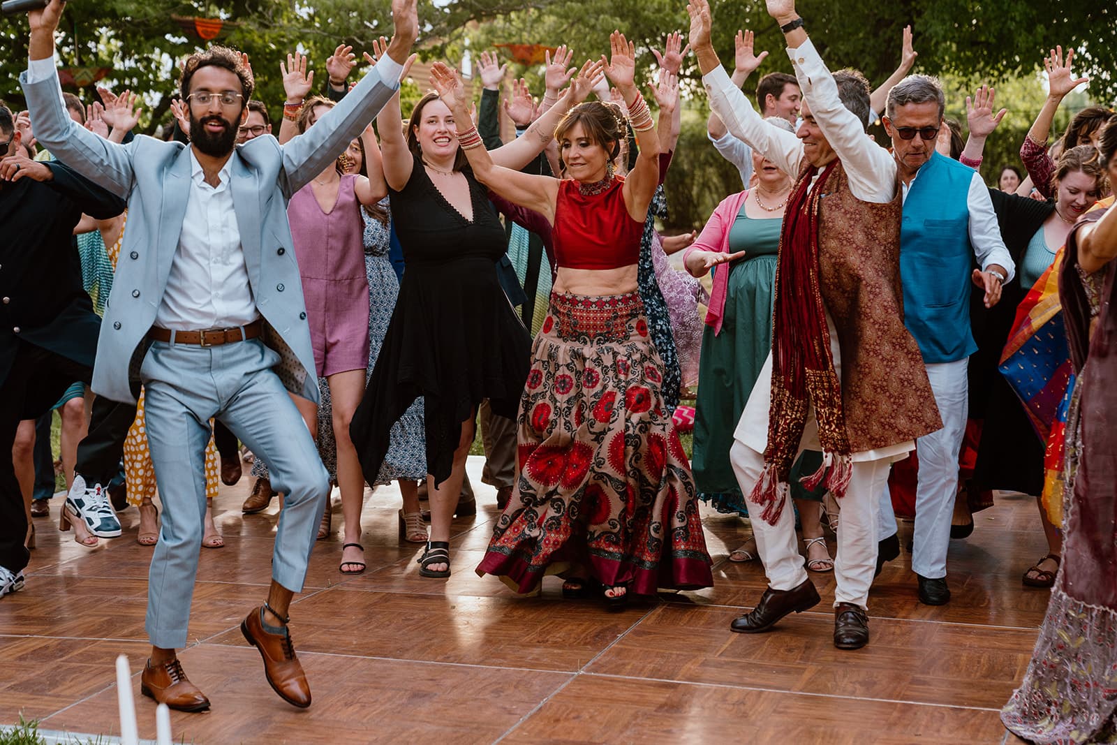 Guests dancing together at outdoor mehndi celebration